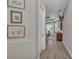Hallway leading to a bedroom with decorative wall art, and hardwood floors at 5529 Mulligan Way, Bradenton, FL 34211