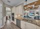 Open kitchen view with stainless appliances, granite counters, and light wood cabinetry overlooking the living area at 5529 Mulligan Way, Bradenton, FL 34211