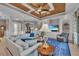 Comfortable living room featuring a coffered ceiling, built-in shelving, and access to outdoor patio at 5529 Mulligan Way, Bradenton, FL 34211