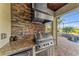 This outdoor kitchen features stone accents, built-in appliances, and granite countertops at 5529 Mulligan Way, Bradenton, FL 34211