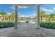 Scenic view of the pool area framed by elegant columns, showcasing tropical landscaping and luxurious amenities at 5529 Mulligan Way, Bradenton, FL 34211