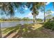 Backyard view of the waterfront with lush green grass and beautiful blue sky at 6326 Grand Oak Cir # 101, Bradenton, FL 34203