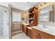 Bright bathroom with double vanity, wood cabinetry and walk-in shower with decorative tile at 6326 Grand Oak Cir # 101, Bradenton, FL 34203