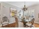 Dining room with round glass table, decorative mirror, hanging light fixture, and hardwood floors at 6326 Grand Oak Cir # 101, Bradenton, FL 34203