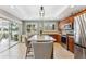 Bright kitchen featuring an island with seating, stainless steel appliances, and a view of the outdoors at 6326 Grand Oak Cir # 101, Bradenton, FL 34203