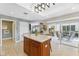 Open concept kitchen with a large island, tile floors and a view into the living room and outdoor dining area at 6326 Grand Oak Cir # 101, Bradenton, FL 34203