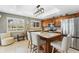 Well-lit kitchen featuring wood cabinets, an island with seating, and stainless steel appliances at 6326 Grand Oak Cir # 101, Bradenton, FL 34203