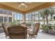 A bright screened lanai features ceiling fan, comfortable chairs, and a water view at 6326 Grand Oak Cir # 101, Bradenton, FL 34203