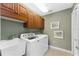 Well-lit laundry room featuring wooden cabinets, tile flooring, and a utility sink at 6326 Grand Oak Cir # 101, Bradenton, FL 34203