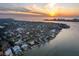 Aerial view of a waterfront community with private docks against a colorful sunset at 679 Norsota Way, Sarasota, FL 34242