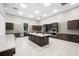 A spacious kitchen featuring dark wood cabinetry and a large island with a light countertop at 7629 Summerland Cv, Bradenton, FL 34202