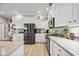 Modern kitchen with stainless steel appliances, light countertops, and white cabinets at 7731 Camden Harbour Dr, Bradenton, FL 34212