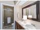Updated bathroom featuring double sinks, a large mirror, and a tiled glass shower at 805 Spring Lakes Blvd # 805, Bradenton, FL 34210