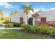 Inviting condo exterior with mature palms, tropical landscaping, and a cozy outdoor seating area at 805 Spring Lakes Blvd # 805, Bradenton, FL 34210