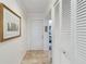 Inviting hallway with neutral tile flooring, white door, closet, and elegant artwork at 805 Spring Lakes Blvd # 805, Bradenton, FL 34210