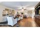 Open-concept living room with a ceiling fan, hardwood floors, and a variety of artwork for a vibrant space at 805 Spring Lakes Blvd # 805, Bradenton, FL 34210
