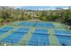 Aerial view of the community's six well-maintained pickleball courts, surrounded by lush landscaping and a peaceful pond at 805 Spring Lakes Blvd # 805, Bradenton, FL 34210