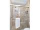 Tiled walk-in shower with glass door and shower niche for toiletries with a hand towel on a horizontal bar at 805 Spring Lakes Blvd # 805, Bradenton, FL 34210