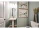Well-lit bathroom with a pedestal sink, decorative mirrors, and modern artwork at 8513 Golden Dawn Ct, Sarasota, FL 34241