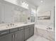 Modern bathroom with double vanity, marble accents, soaking tub, and a glass-enclosed shower at 8609 Evening Dr, Sarasota, FL 34241