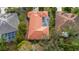 Aerial view of the property showcasing a terracotta roof, screened-in pool area, and green landscaping at 8717 54Th E Ave, Bradenton, FL 34211