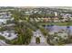 Scenic aerial view of the neighborhood entrance, a tranquil lake, and surrounding lush greenery at 8717 54Th E Ave, Bradenton, FL 34211