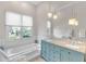 Bright bathroom featuring a blue double vanity and large tub with natural lighting at 8717 54Th E Ave, Bradenton, FL 34211