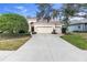 Well-maintained home featuring a lush front lawn, mature trees, and a two-car garage at 8717 54Th E Ave, Bradenton, FL 34211