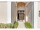 View of the home's arched front entryway with double doors and manicured landscaping at 8717 54Th E Ave, Bradenton, FL 34211