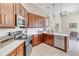 Modern kitchen with stainless steel appliances, wood cabinetry, and a breakfast bar at 8717 54Th E Ave, Bradenton, FL 34211