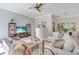 Cozy living room with a ceiling fan, shelving, and large windows showcasing the natural outdoor landscape at 8717 54Th E Ave, Bradenton, FL 34211