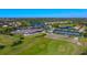 An aerial view showcasing the sprawling community with golf course, lakes, tennis courts, and lush greenery at 8735 Olde Hickory Ave # 8210, Sarasota, FL 34238