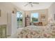 Bright bedroom with outdoor views, floral bedding, and desk area at 8735 Olde Hickory Ave # 8210, Sarasota, FL 34238