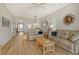 Open-concept living room with hardwood floors and a view of the kitchen at 8735 Olde Hickory Ave # 8210, Sarasota, FL 34238