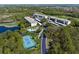 Aerial view of condo buildings, pool, and tennis courts nestled amidst a picturesque golf course and lake at 9540 High Gate Dr # 1426, Sarasota, FL 34238