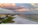 Aerial shot of the beachside properties against the stunning backdrop of the ocean and sunset clouds at 9540 High Gate Dr # 1426, Sarasota, FL 34238