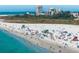 Aerial view of white sand beach full of people and lifeguard towers, in front of hotels and green space at 9540 High Gate Dr # 1426, Sarasota, FL 34238