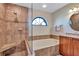 Bathroom featuring soaking tub, shower with seat, and decorative window at 104 Inlets Blvd # 104, Nokomis, FL 34275