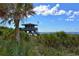 Scenic view of a lifeguard tower along a serene beach with lush greenery and a clear blue sky at 104 Inlets Blvd # 104, Nokomis, FL 34275