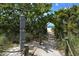 Beach access through a path covered with greenery and a post to provide support at 104 Inlets Blvd # 104, Nokomis, FL 34275