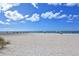 Expansive white sand beach with scattered umbrellas and people enjoying a sunny day by the ocean at 104 Inlets Blvd # 104, Nokomis, FL 34275