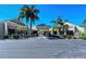 Beautiful clubhouse entrance lined with mature palm trees, convenient bike racks, and covered entrance at 104 Inlets Blvd # 104, Nokomis, FL 34275