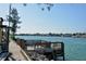 Scenic waterfront view with a pier, tranquil water, and picturesque homes in the distance at 104 Inlets Blvd # 104, Nokomis, FL 34275