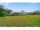 View of the home's back exterior and a spacious backyard with lawn, showing the property's outdoor space at 1124 Ample Ave, Port Charlotte, FL 33948