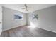 Bright bedroom featuring new laminate floors, a modern ceiling fan, and natural light from two windows at 1124 Ample Ave, Port Charlotte, FL 33948