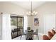 Dining room with a modern light fixture and sliding doors to the lanai at 124 Mark Twain Ln, Rotonda West, FL 33947