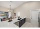 Kitchen with a large island and sleek black faucet, extending to an outdoor pool area view at 124 Mark Twain Ln, Rotonda West, FL 33947