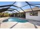 Relaxing screened-in pool area, perfect for entertaining, with a tranquil view of the yard at 124 Mark Twain Ln, Rotonda West, FL 33947