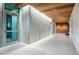 Modern hallway with wood ceilings and concrete accent wall leading to elevators at 1335 2Nd St # 402, Sarasota, FL 34236