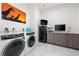 Convenient laundry room equipped with modern washer and dryer, ample counter space, and a stylish giraffe-themed art piece at 1335 2Nd St # 402, Sarasota, FL 34236